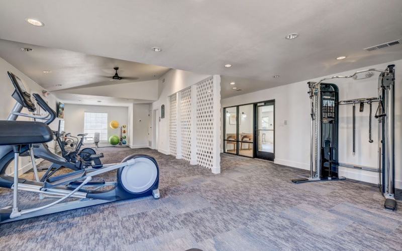 spacious fitness center on carpet and with modern equipment